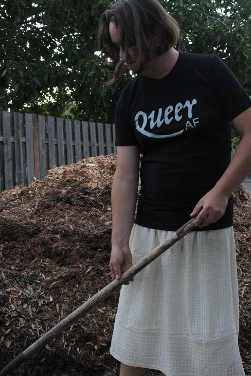 Jaelyn wearing the Queer AF shirt in the garden and shoveling