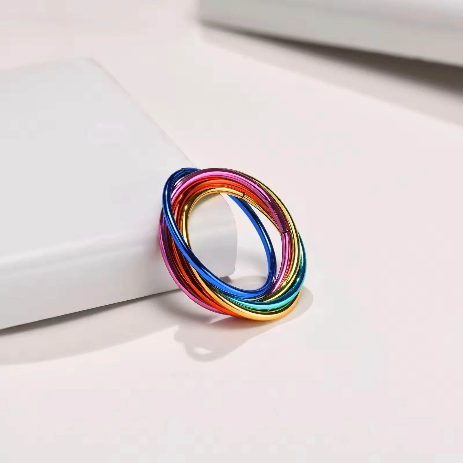 Rainbow Fidget Ring leaning against a tile